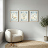Minimalist nursery decor with framed moon, hot air balloon, and sheep wall art, cozy chair, and toys