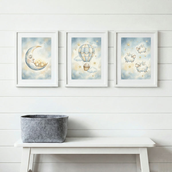 Nursery wall art trio with moon, hot air balloon, and sheep, framed above white bench